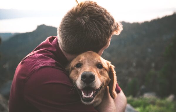 Ein Mann knuddelt seinen Hund - Tiere sind manchmal die besten Therapeuten